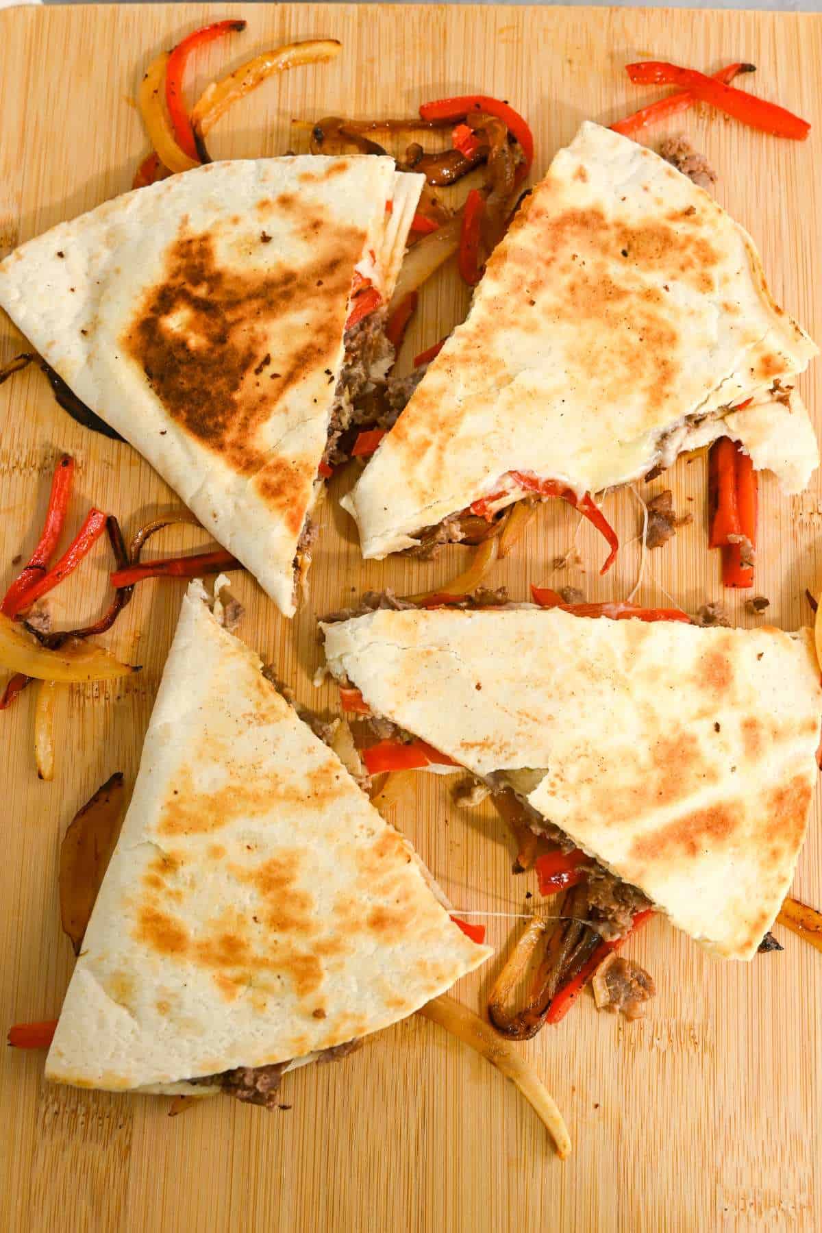top down view of four triangles of a cut beef steak quesadilla.