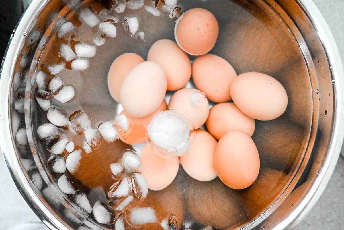 photo of eggs cooling in an ice bath in a silver bowl.