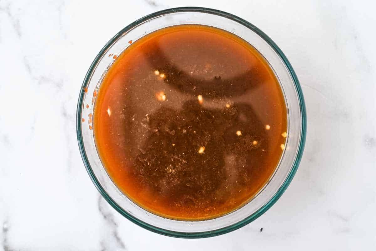 bbq sauce ingredients in a glass dish on white background.
