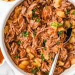close up view of pineapple pulled pork topped with cilantro with a spoon in a white bowl.