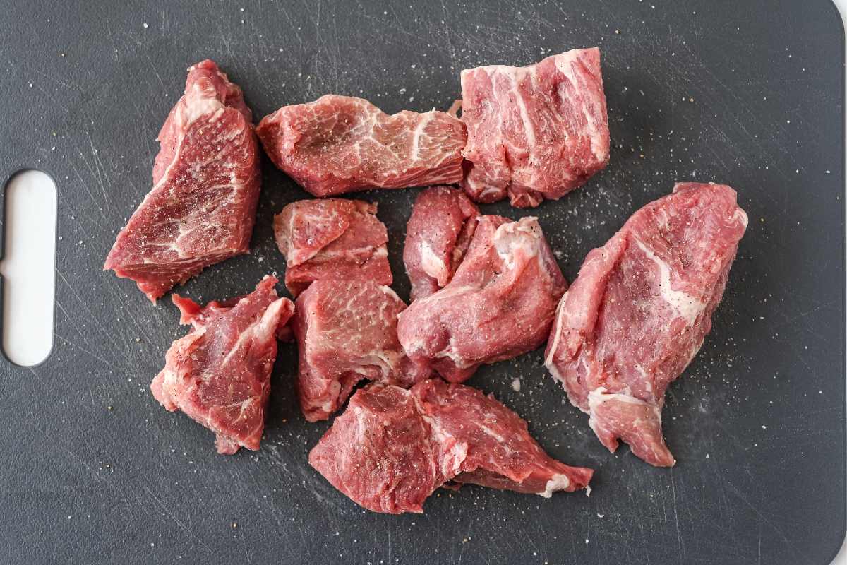 seasoned pork shoulder chunks on a gray cutting board.