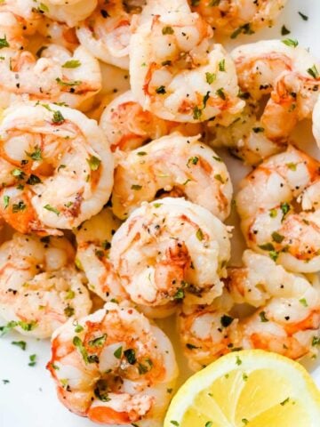 close up of shrimp in a bowl with lemon.