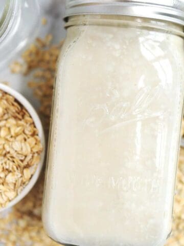 close up of oat milk in a glass jar.
