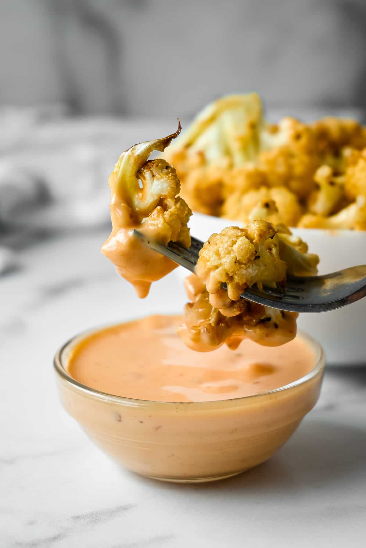 cauliflower wings dipped in bang bang sauce