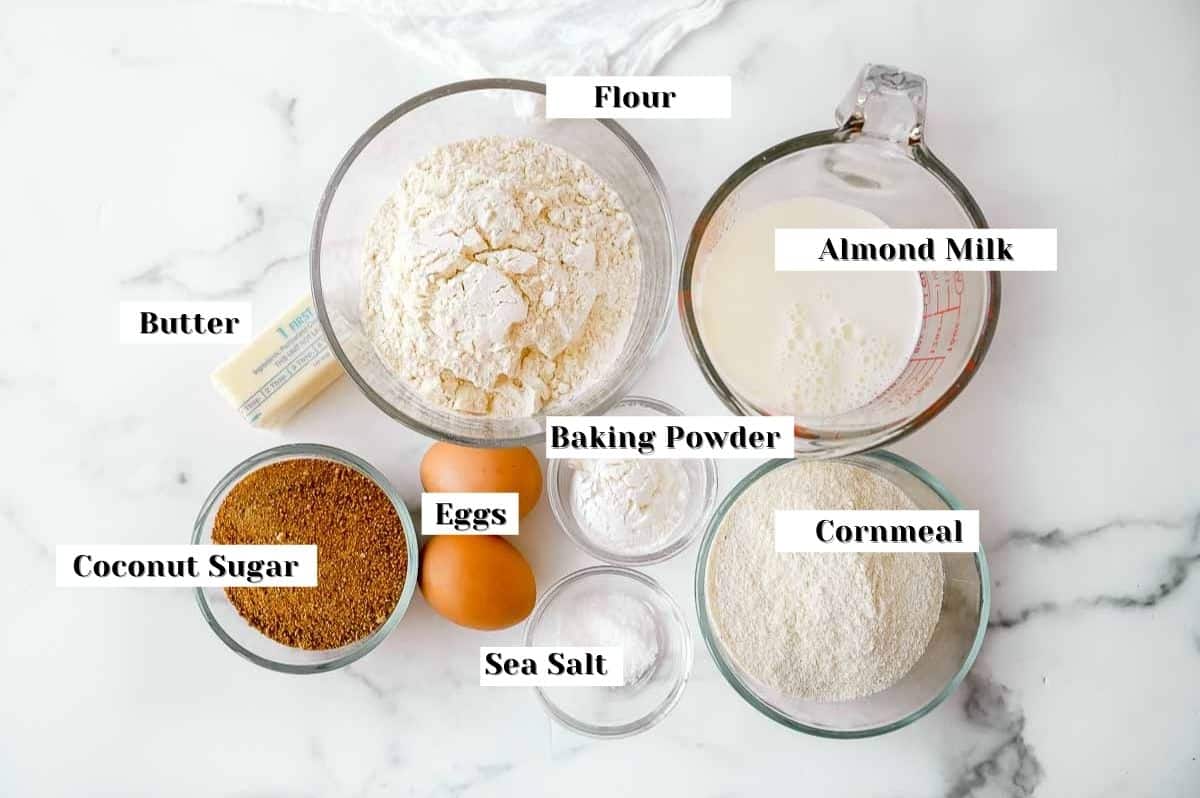 labeled ingredients for cornbread recipe without milk on a white background.