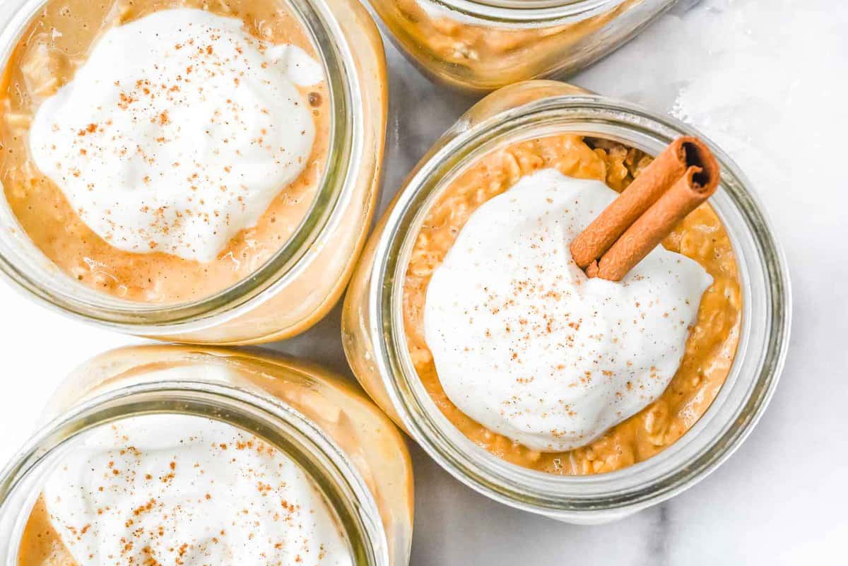 top down view of pumpkin spice overnight oats topped with yogurt and a cinnamon stick.