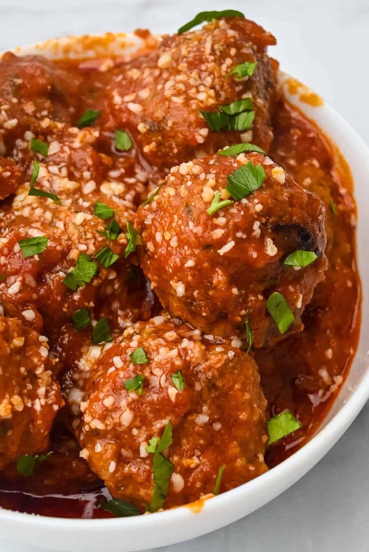 bowl of instant pot turkey meatballs with marinara sauce topped with parmesan cheese and parsley