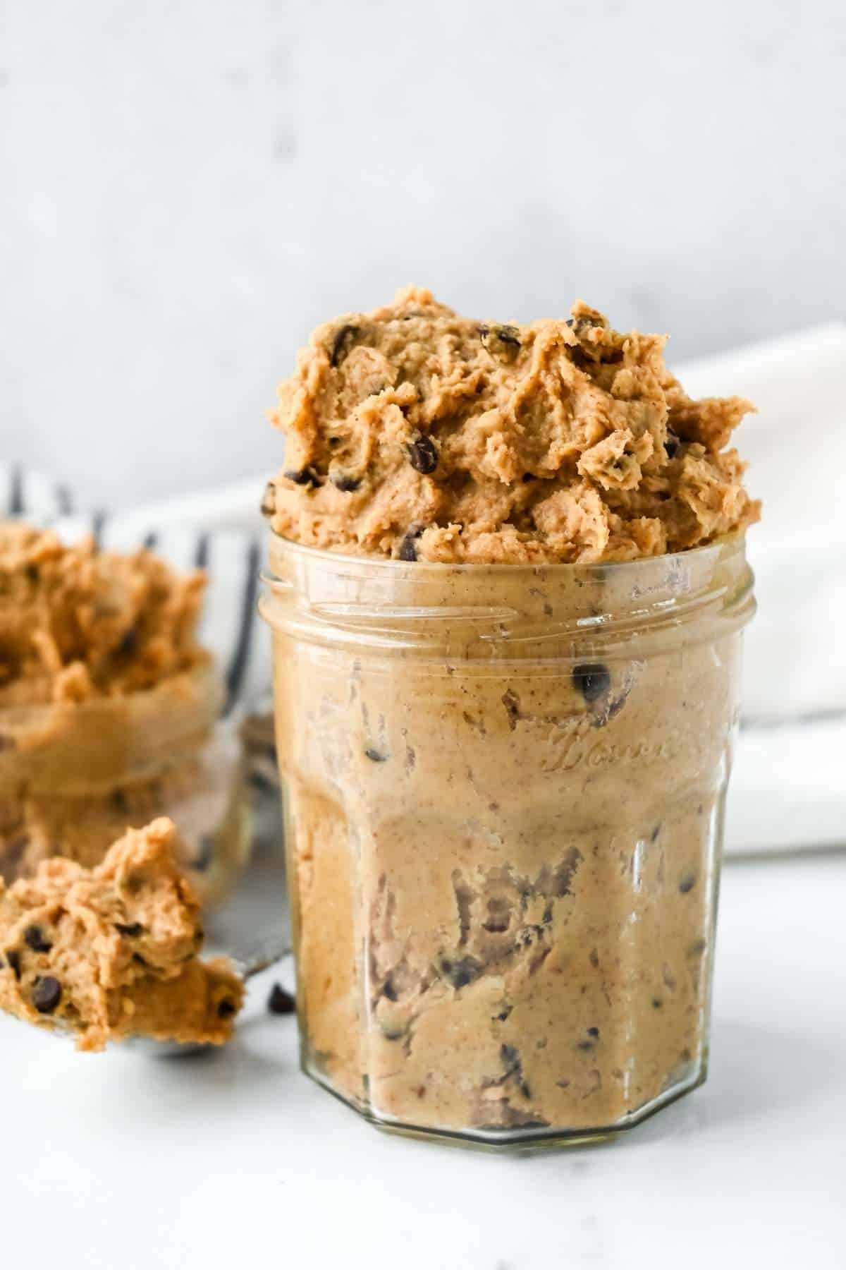chocolate chip cookie dough hummus in a jar and on a spoon.
