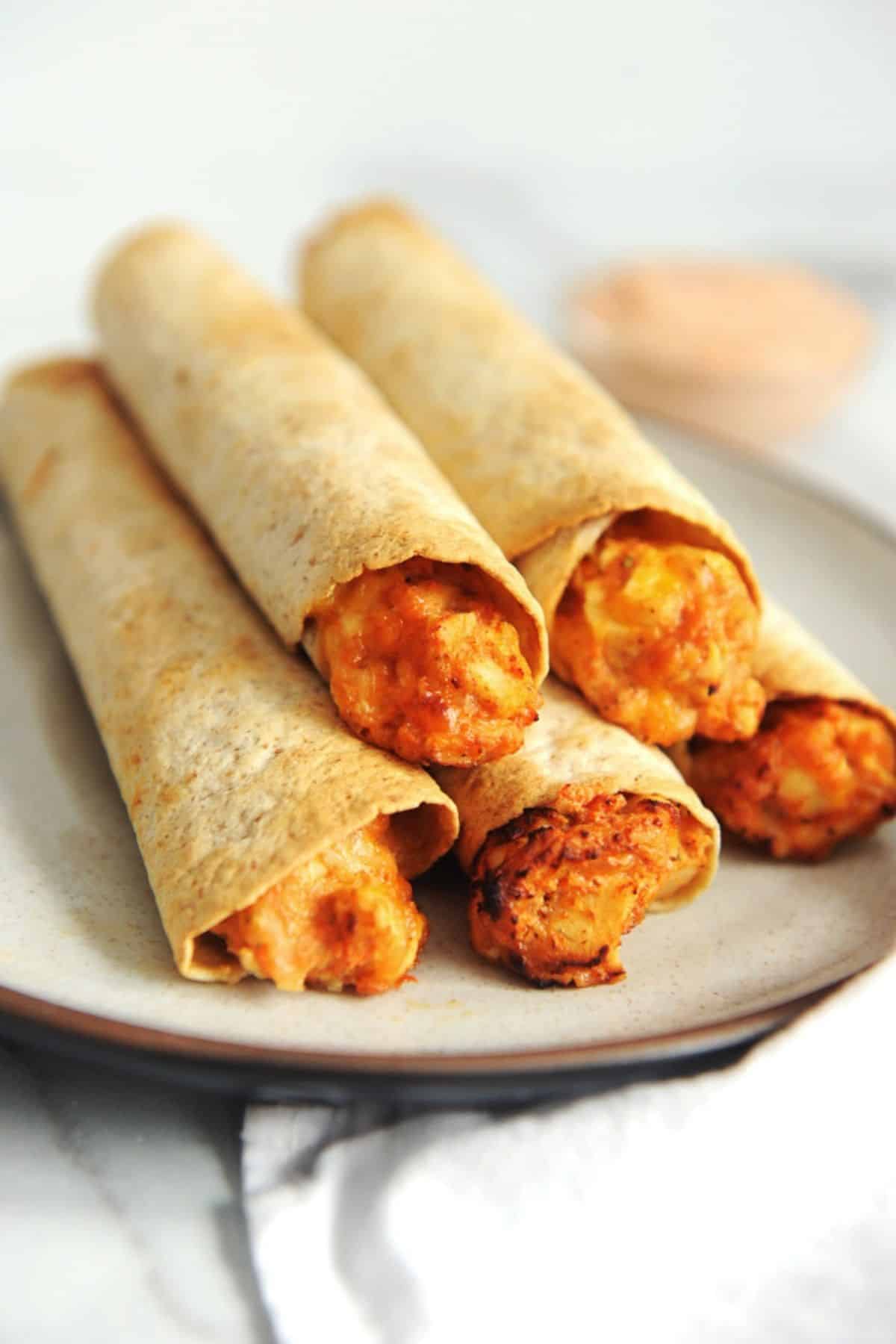 plate of air fryer chicken taquitos in a stack.