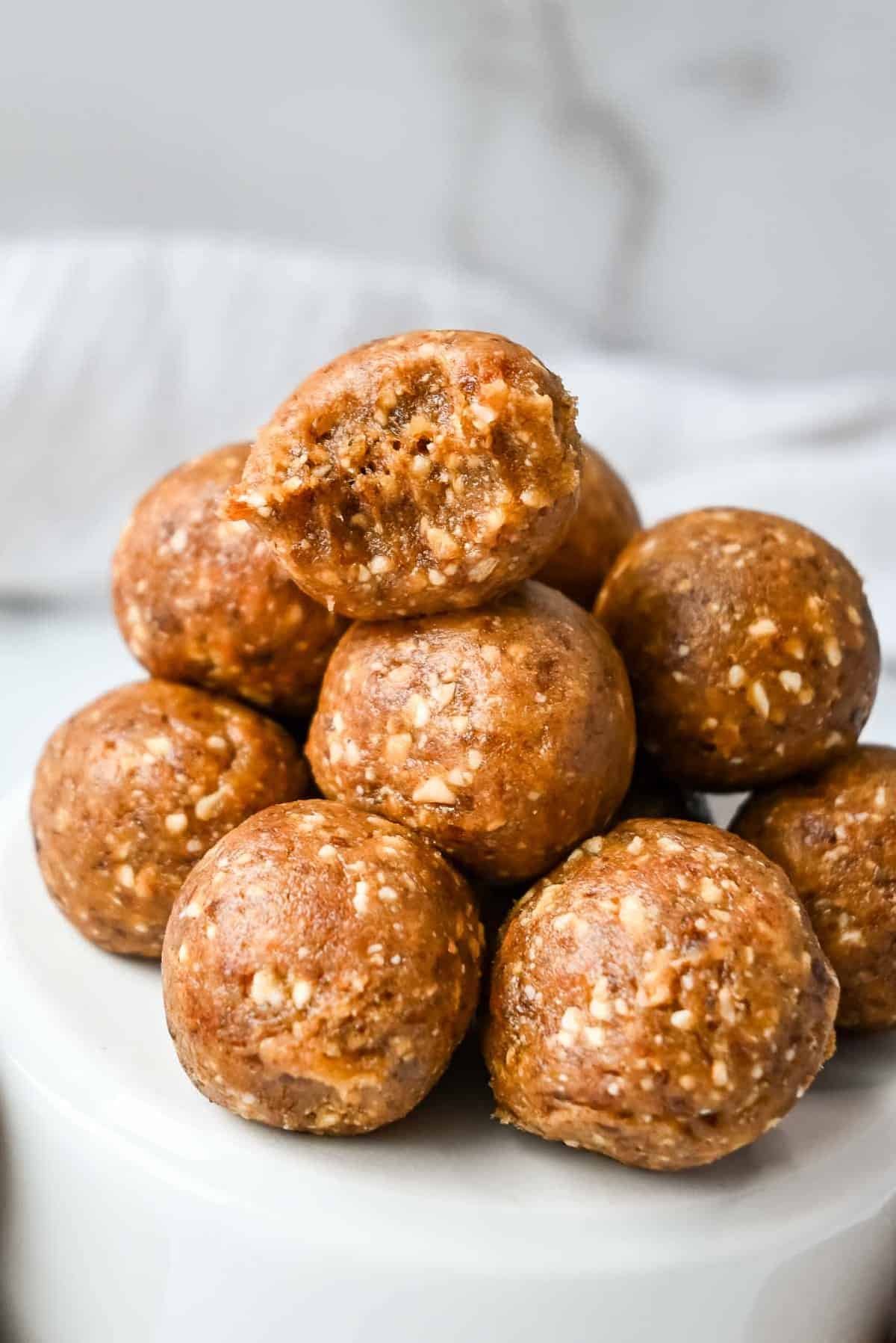 energy balls with dates in a stack with a bite taken out of the top one to show texture