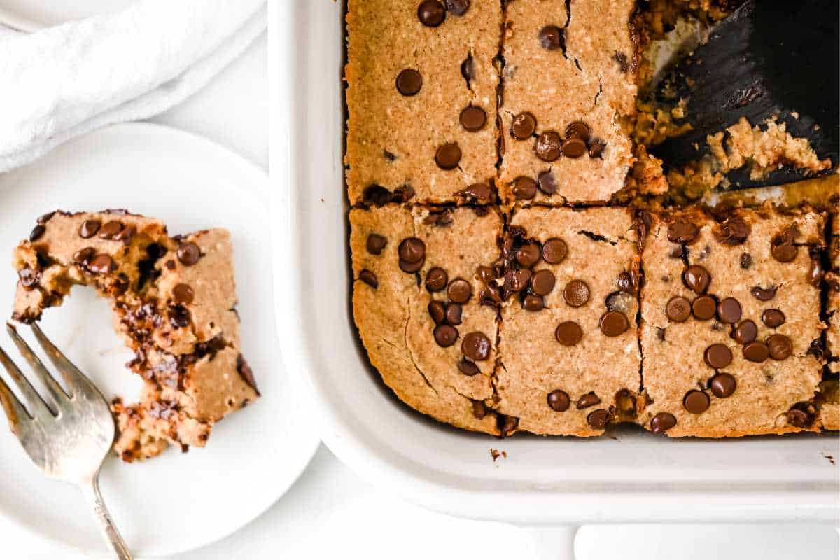 slices of protein baked oatmeal in a white pan and on a white dish with a fork.