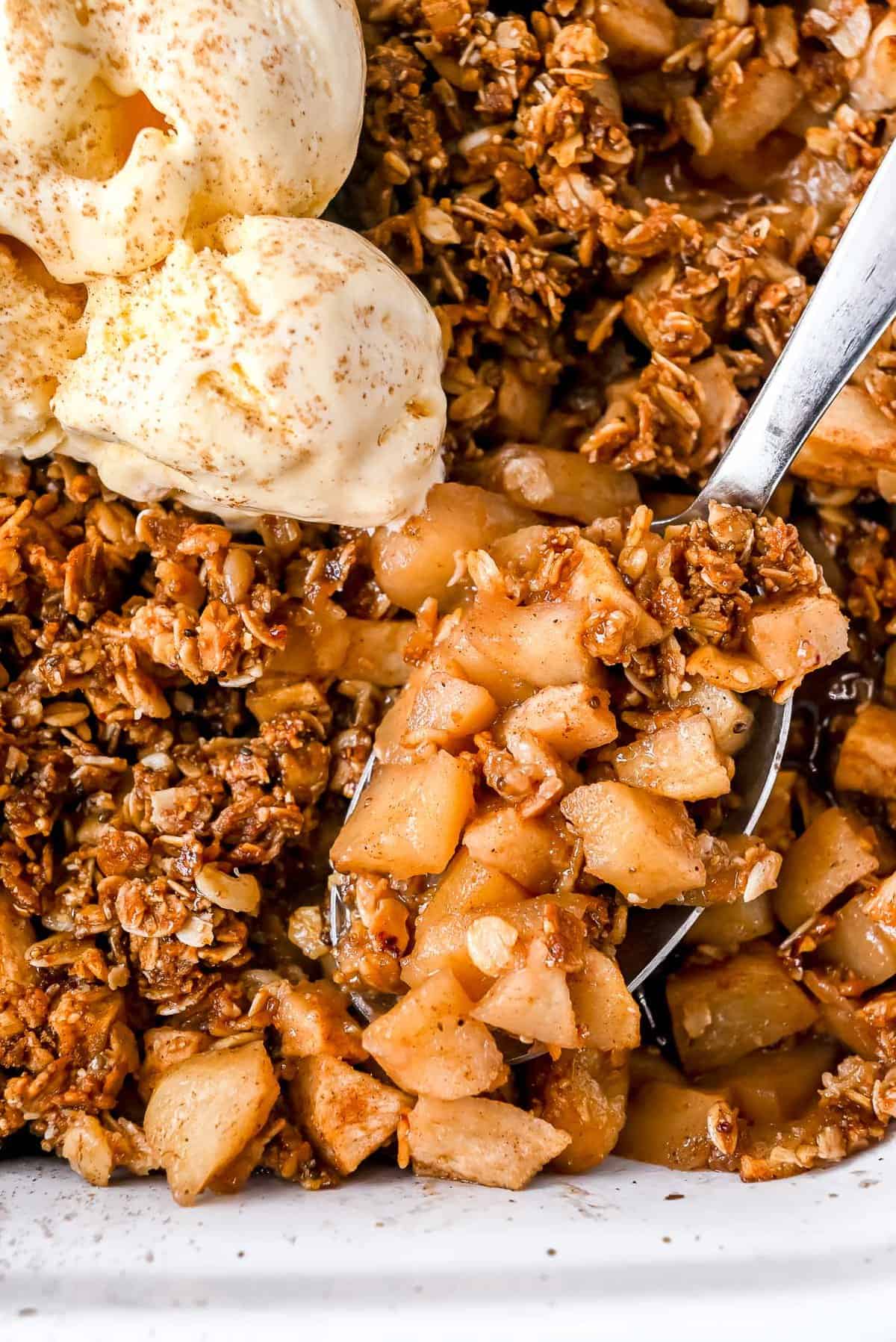 spoonful of apple crisp with vanilla ice cream.