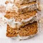 close up of gingerbread loaf with cream cheese frosting slices.