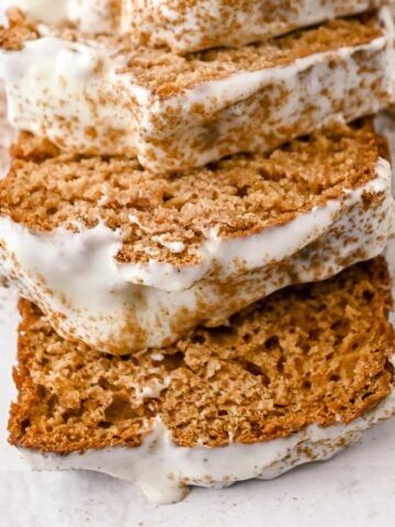 close up of gingerbread loaf with cream cheese frosting slices.
