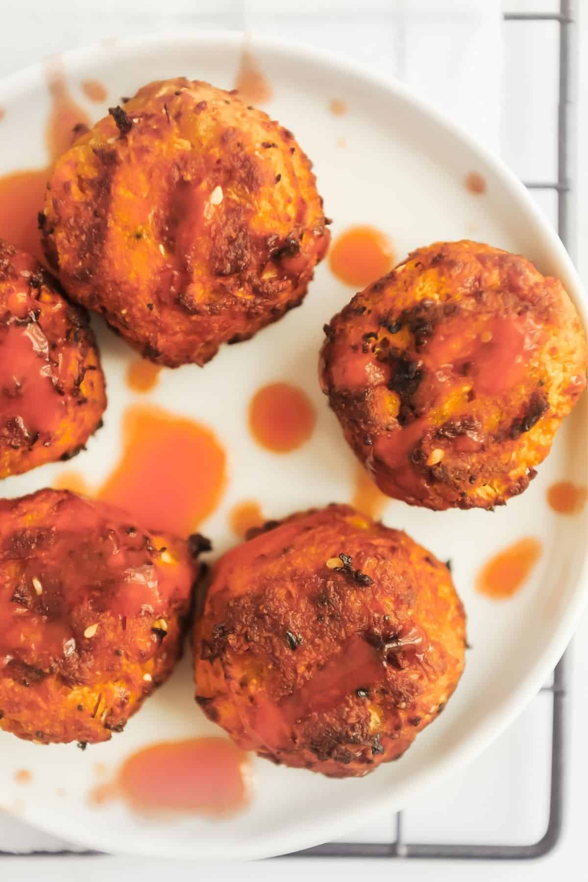 plate of sweet potato hash browns made in the air fryer and drizzled with hot sauce
