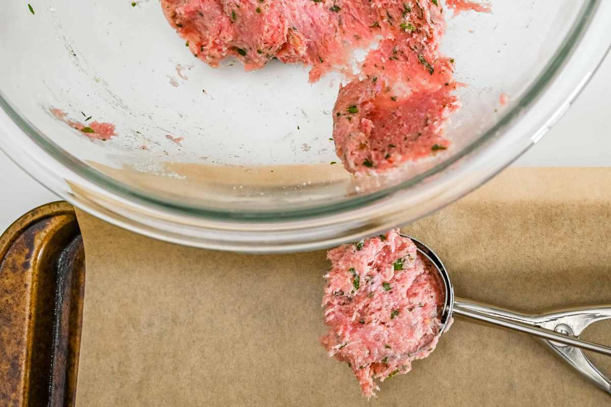 scooping meatballs with an ice cream scoop.