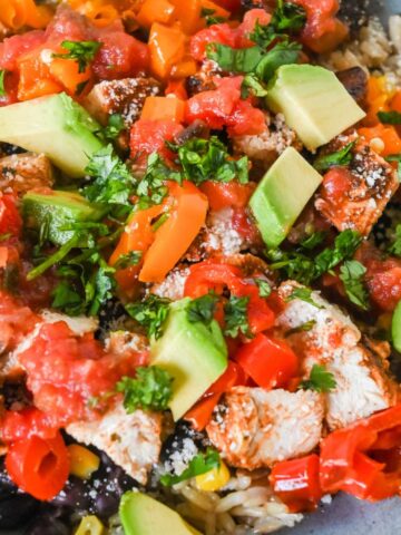 close up shot of southwest chicken bowl topped with cilantro and avocado.