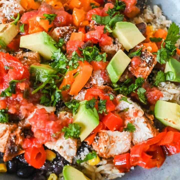 close up shot of southwest chicken bowl topped with cilantro and avocado.