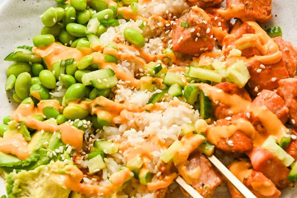 close up of salmon teriyaki bowl topped with sriracha mayo.