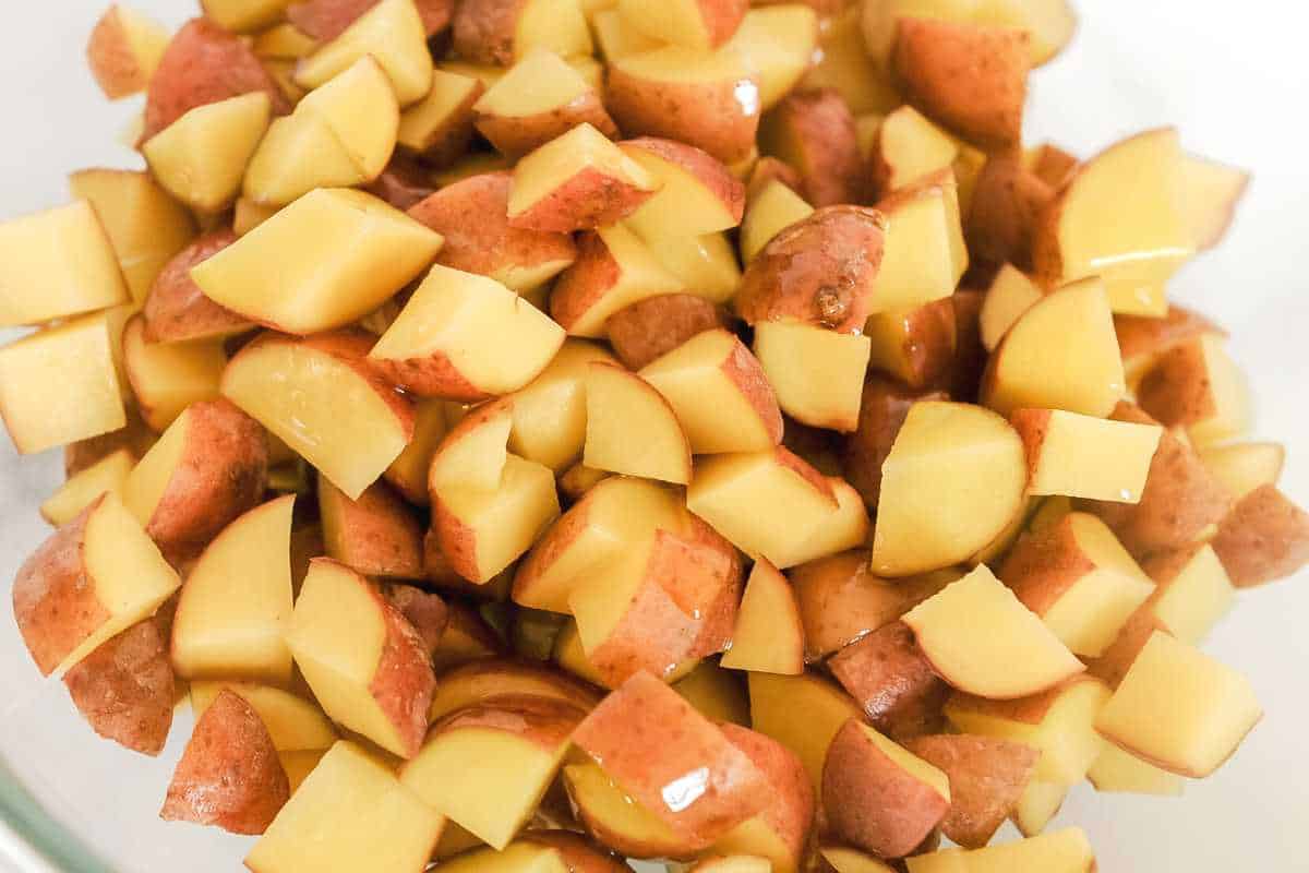 close up shot of diced breakfast potatoes with a drizzle of olive oil.