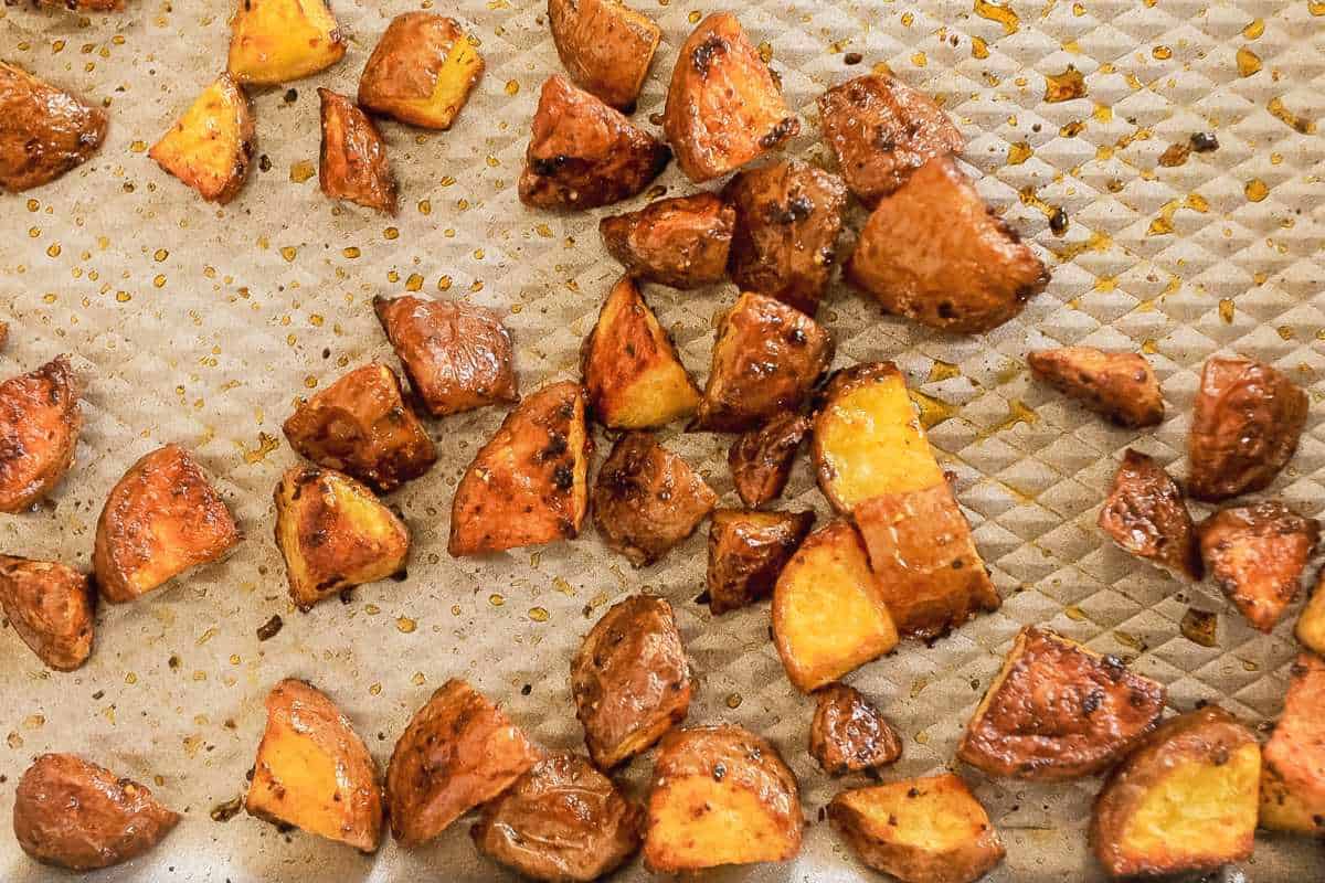 close up shot of cubed breakfast potatoes on a roasting pan.