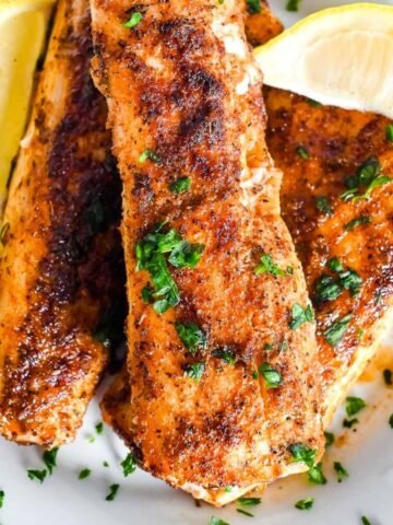 close up of air fryer mahi mahi topped with parsley and fresh lemon.