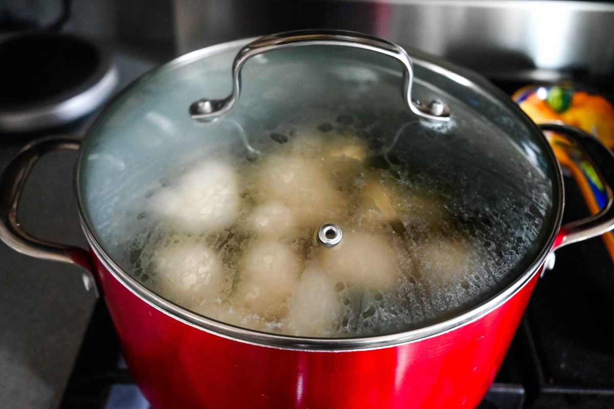 stock pot with cooking potatoes and cauliflower with a glass lid.