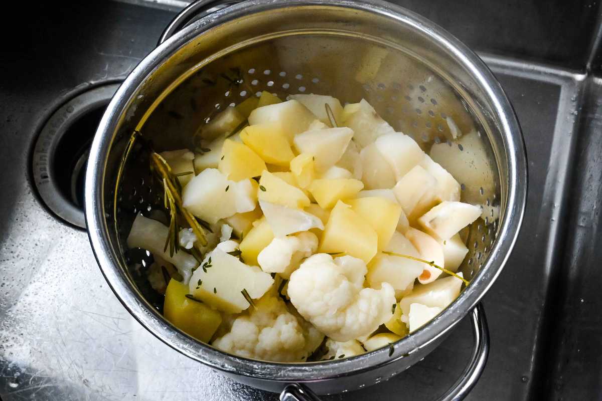 cooked potatoes and cauliflower in a colander.
