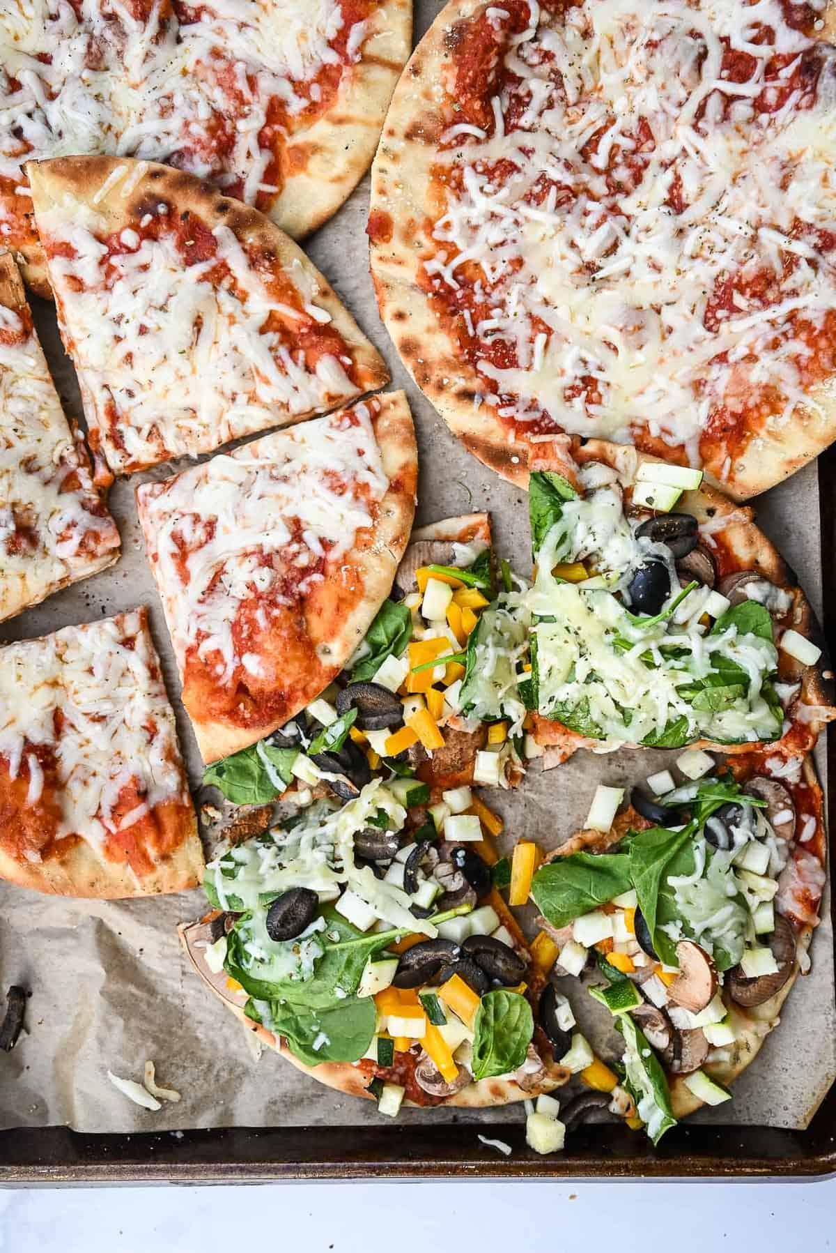 slices of cheese and veggie pizza on a sheet pan.