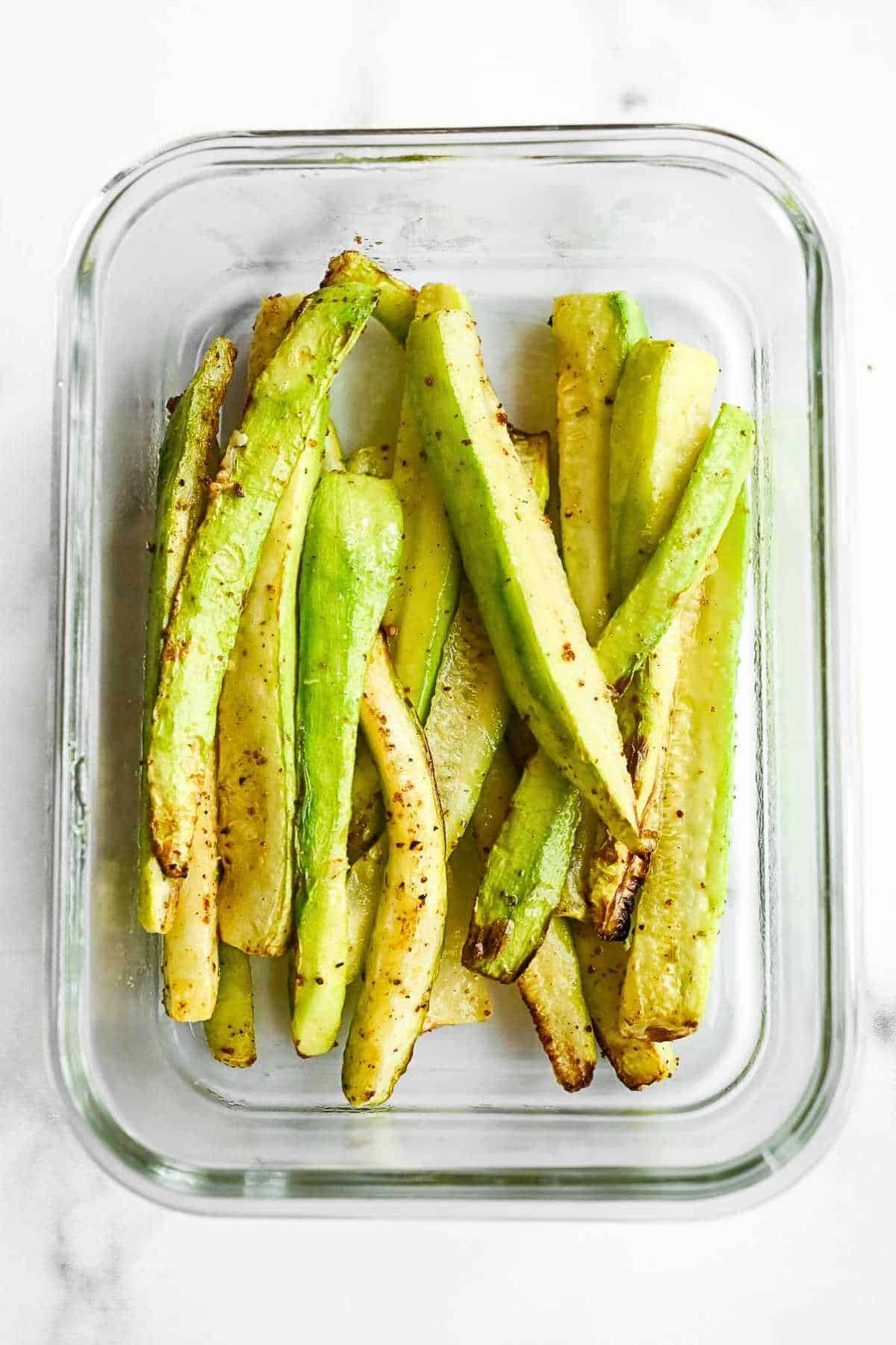 zucchini sticks with no breading in a glass dish.