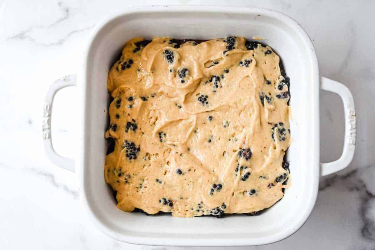 unbaked blackberry cobbler in a white dish.