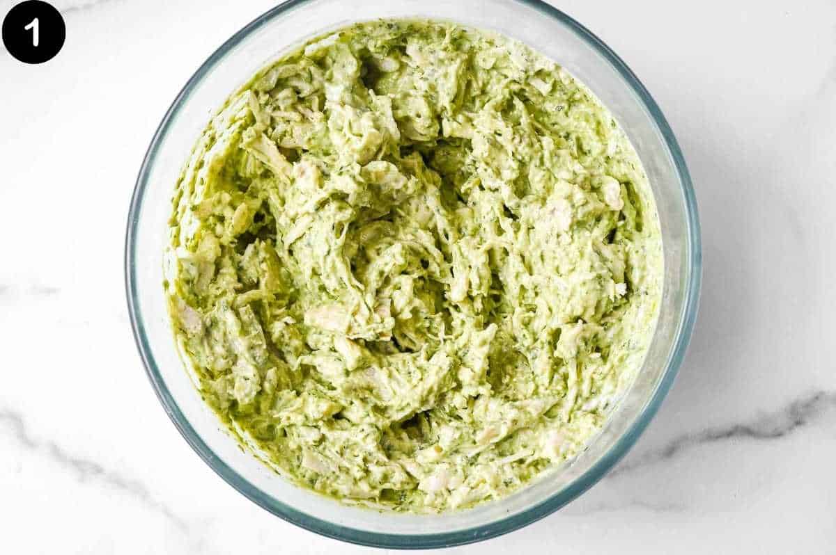 bowl of pesto chicken salad on a white background.