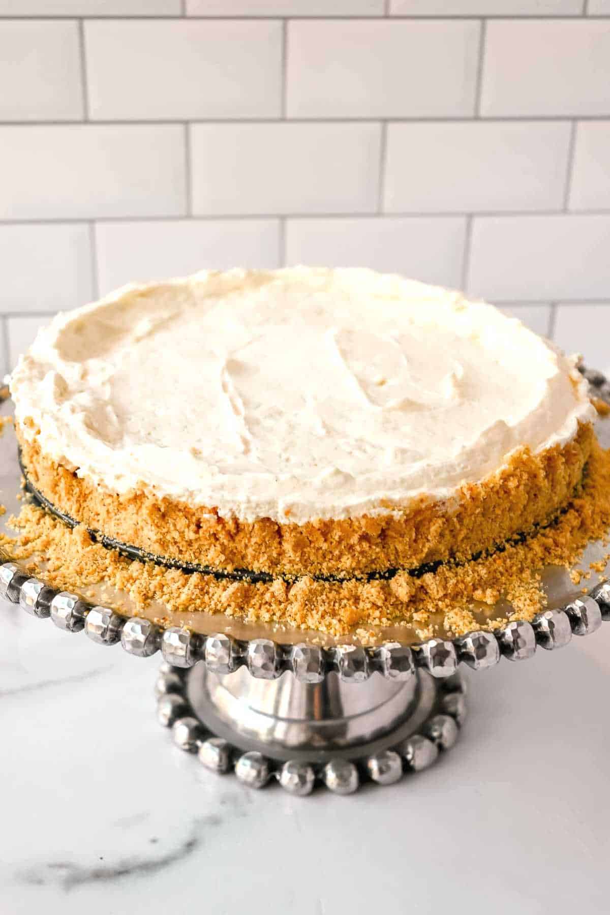 full cheesecake on a cake platter.