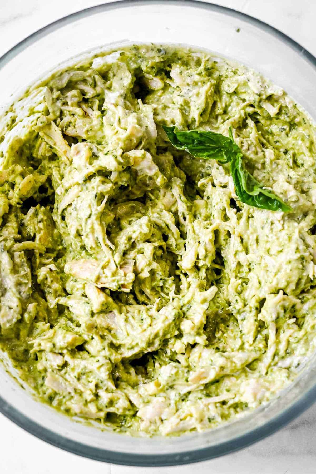 pesto chicken salad in a round glass bowl.