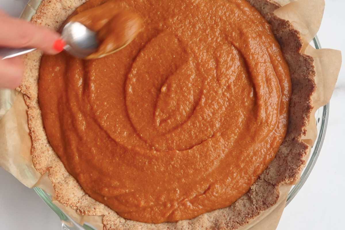 unbaked pumpkin pie filling in pie crust.