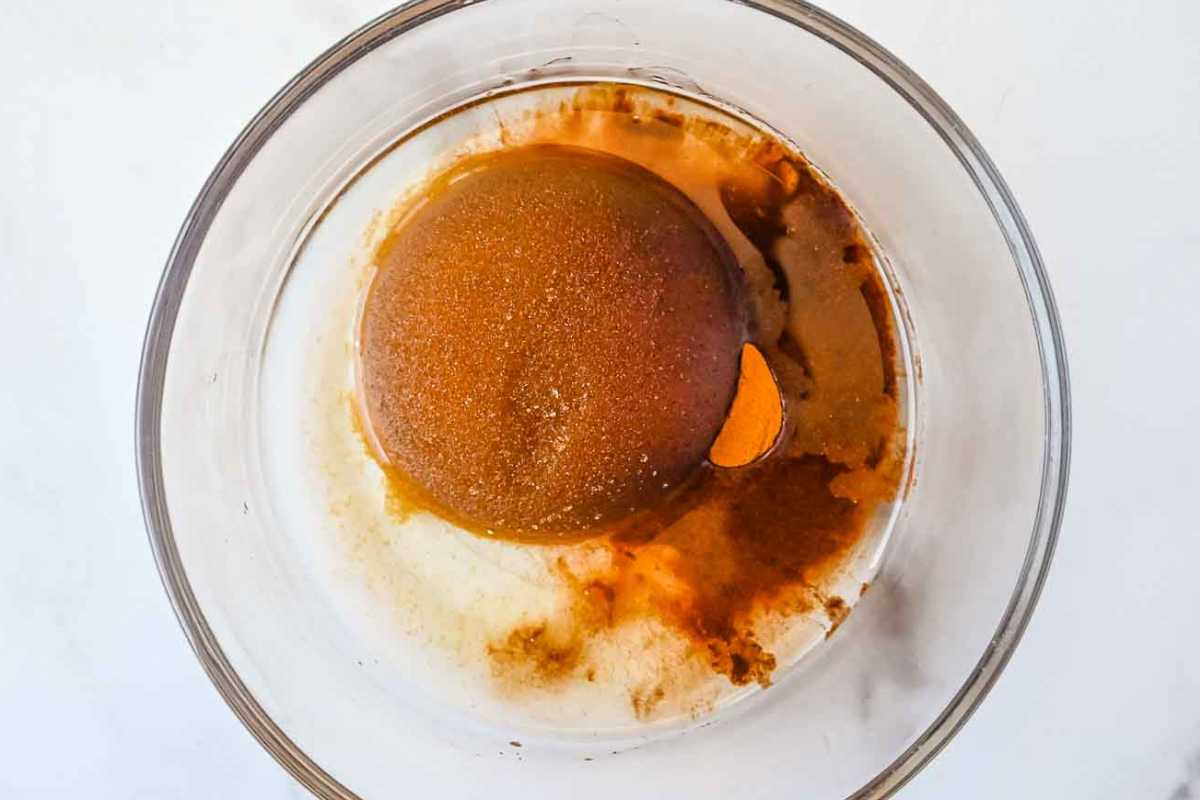 cinnamon, brown sugar, oat milk, and other ingredients in a glass bowl on a white background.