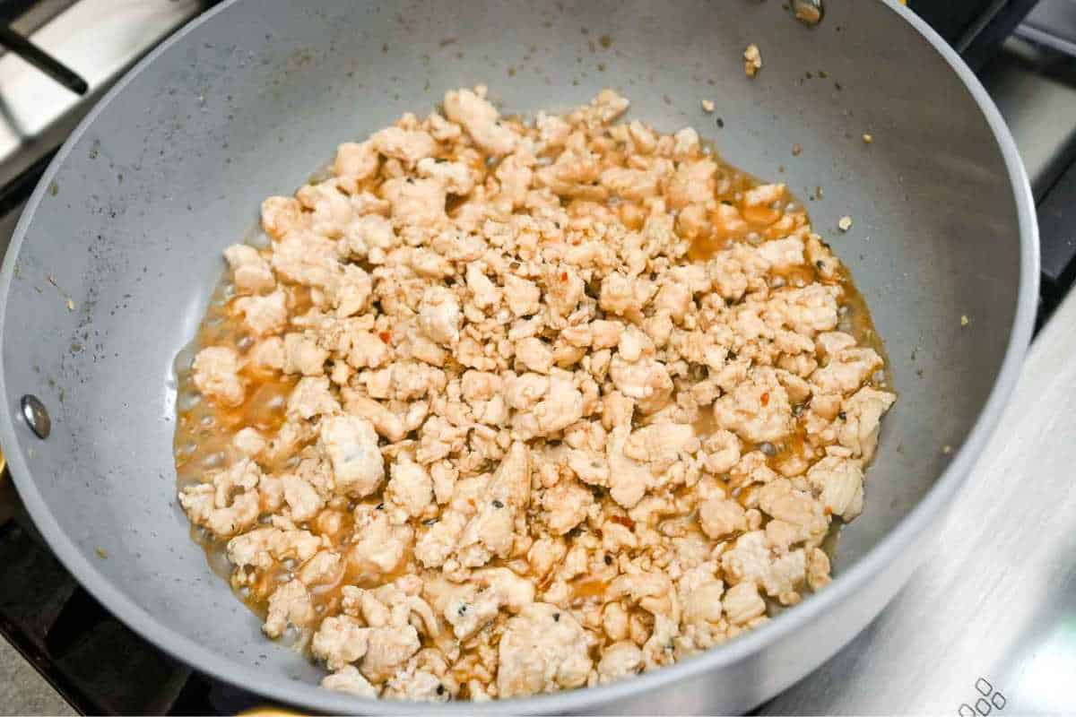 ground chicken cooking in a gray pan.