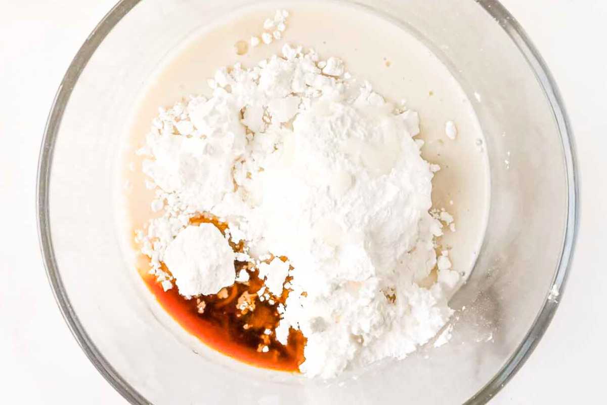 cinnamon roll glaze ingredient in a glass bowl on a white background.