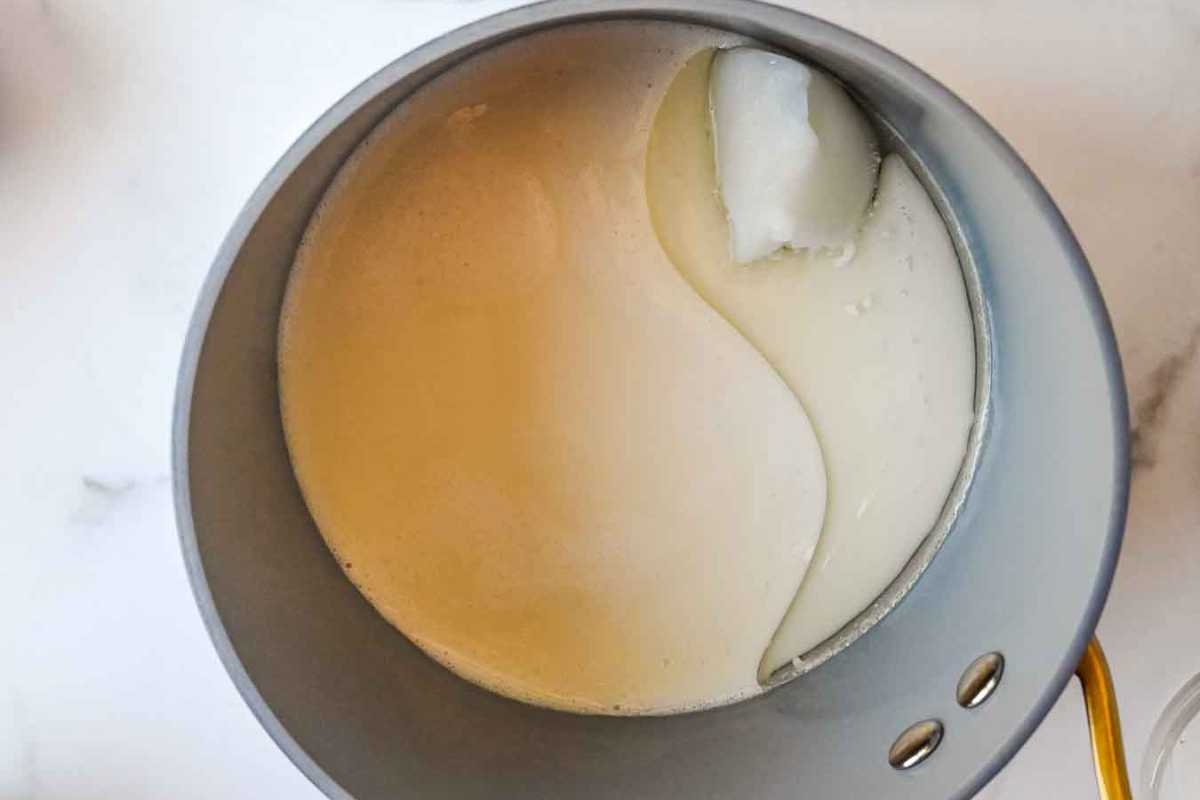 milk and coconut oil heated in a sauce pan on a white background.