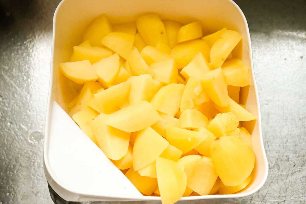 cooked potatoes in a white colander.