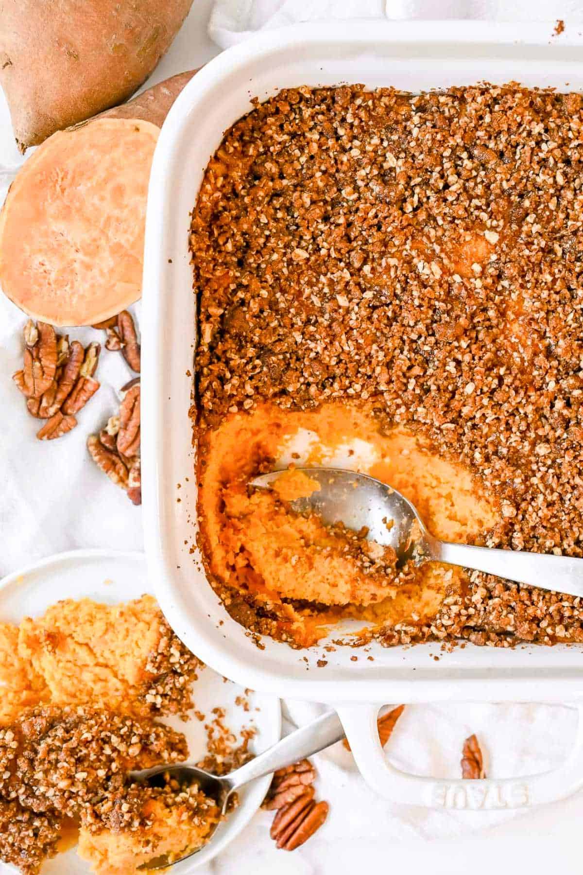 full pan of ruth's chris sweet potato casserole with a scoop out on a white plate.