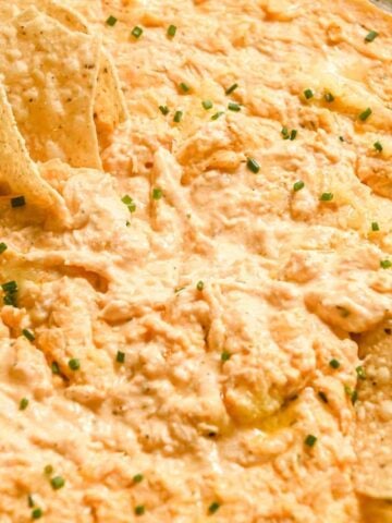 close up of Greek yogurt buffalo chicken dip with tortilla chips and celery.