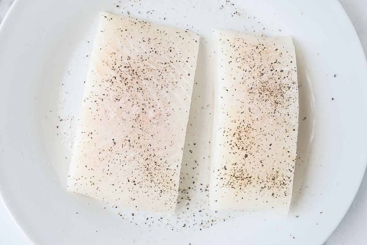 seasoned air fryer halibut on a white plate.