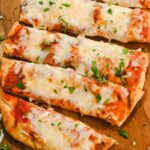 close up of air fryer naan pizza on a wood cutting board.