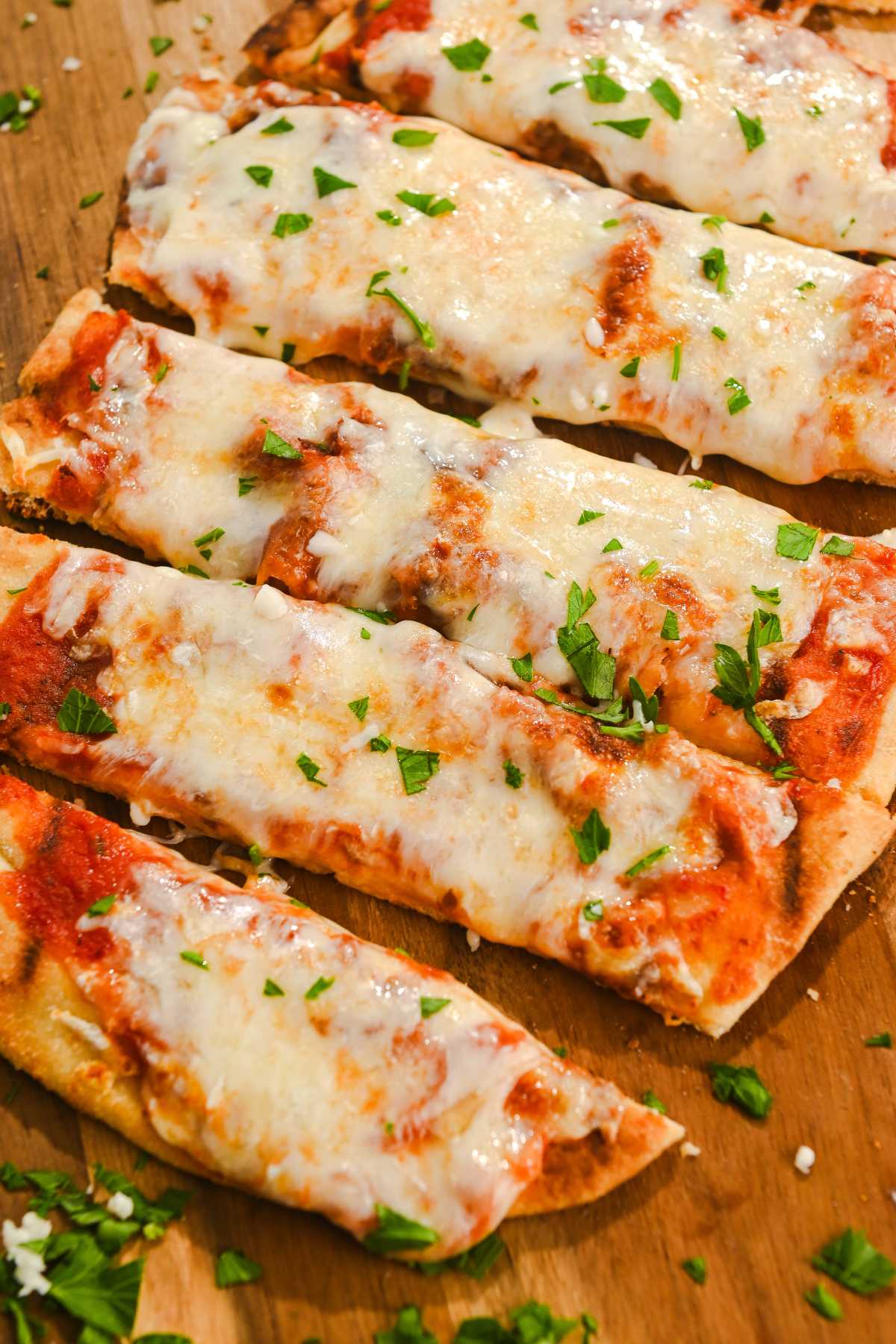 air fryer naan pizza sliced into strips and topped with parsley.