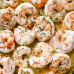 close up shot of pan seared shrimp topped with parsley.