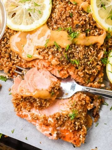 featured image for this almond crusted salmon recipe showing closeup of fish flaking on a fork.