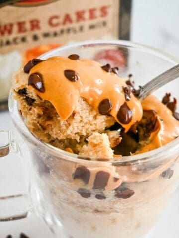 close up shot of pancake in a glass mug with spoon and box in the background.