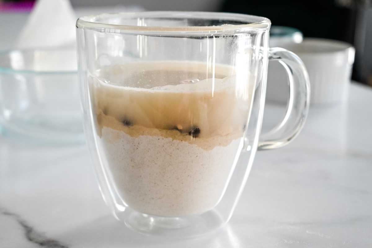mug pancake ingredients layered in a clear mug.