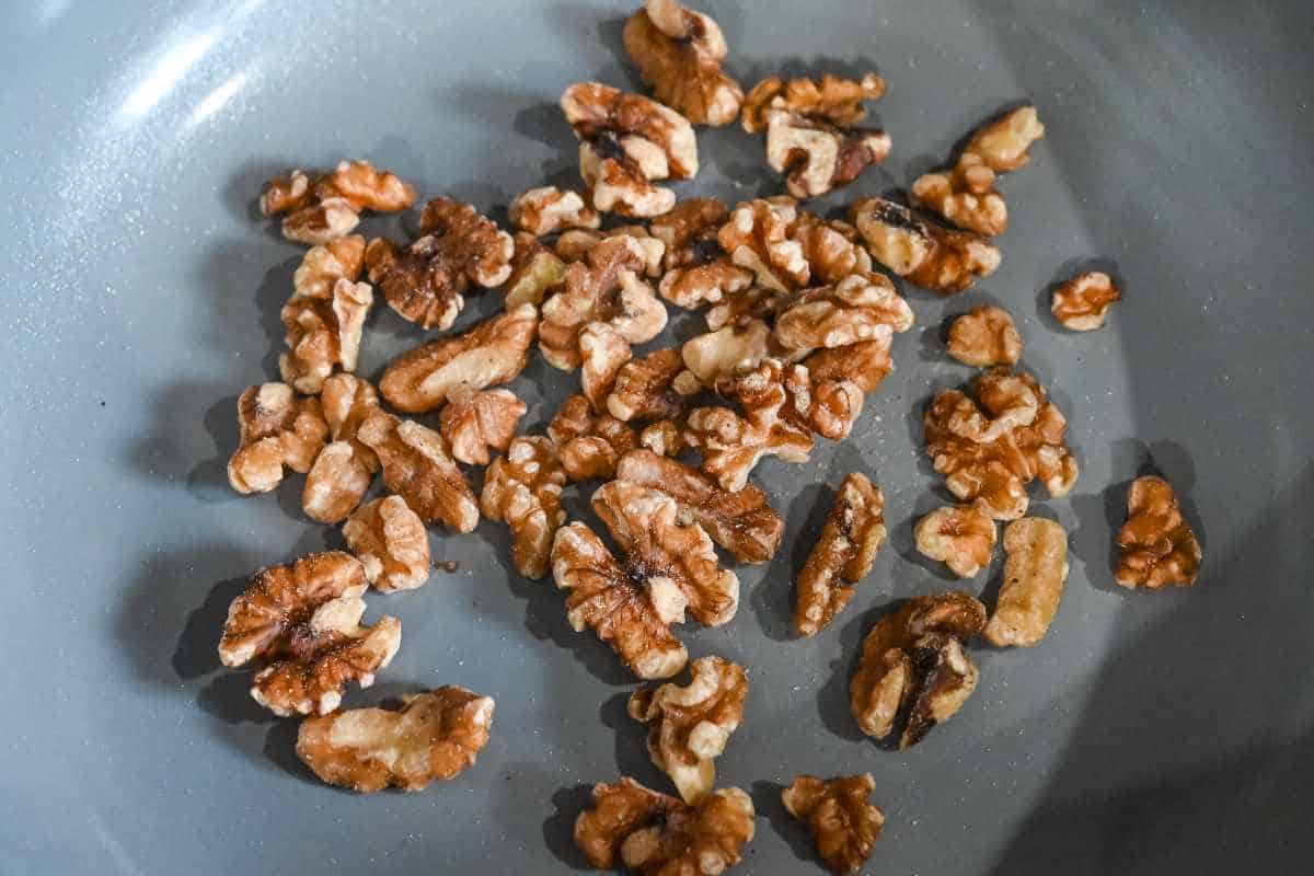 walnuts in a gray skillet.